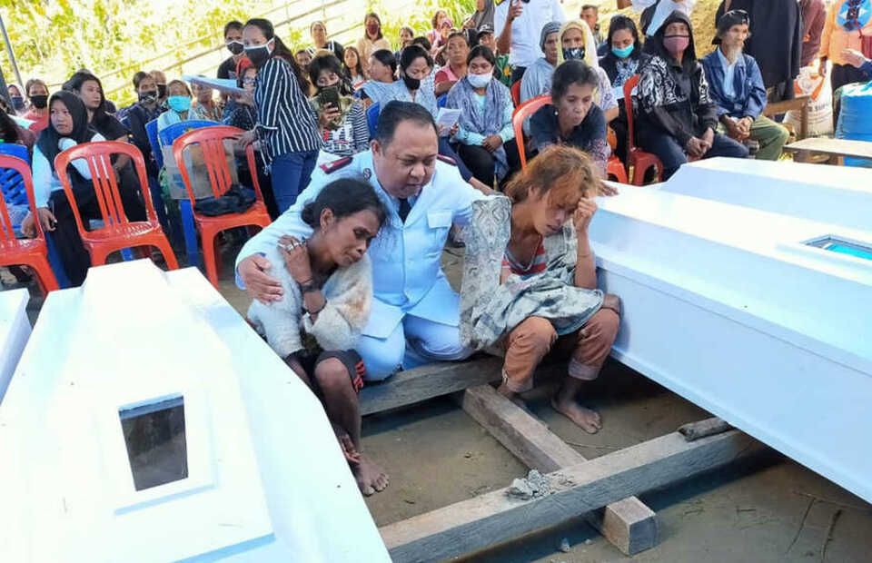 Erik A. Kape, The Salvation Army's commander for Palu, center, consoles the East Indonesia Mujahidin attack victims' widows during a funeral ceremony in Sigi, Central Sulawesi on Saturday. (B1 Photo)