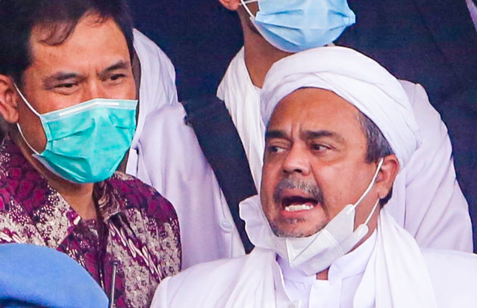 Rizieq Syihab, right, arrives at the Jakarta Police Headquarters for a questioning on Dec. 13, 2020. (Beritasatu Photo/Ruht Semiono)