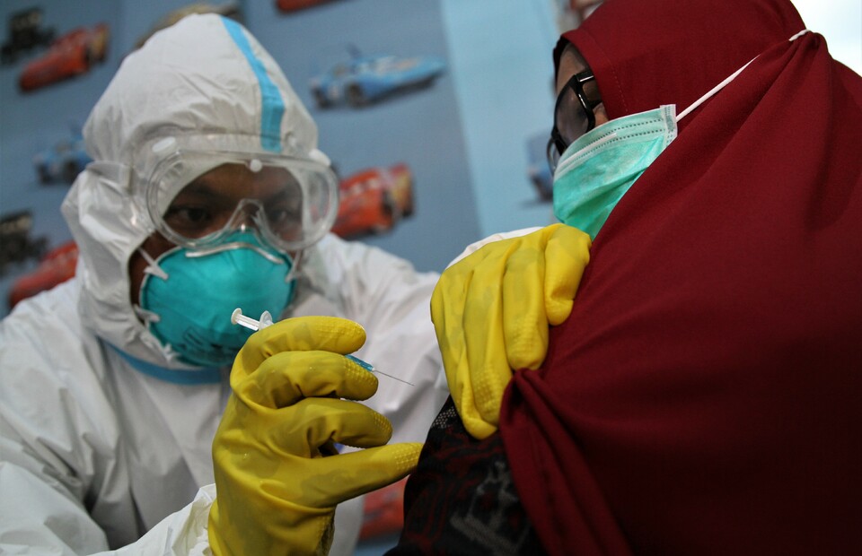 A health worker administered a mock dose of vaccine to a woman during a trial run in Kendari, Southeast Sulawesi, on Dec 21, 2020. (Antara Photo/Jojon)