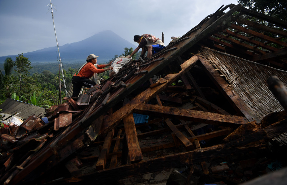 Locals salvage valuables from ruins in Lumajang, East Java on Sunday, after a 6.7 magnitude earthquake levelling the house a day earlier. (Antara Photo/Zabur Karuru)