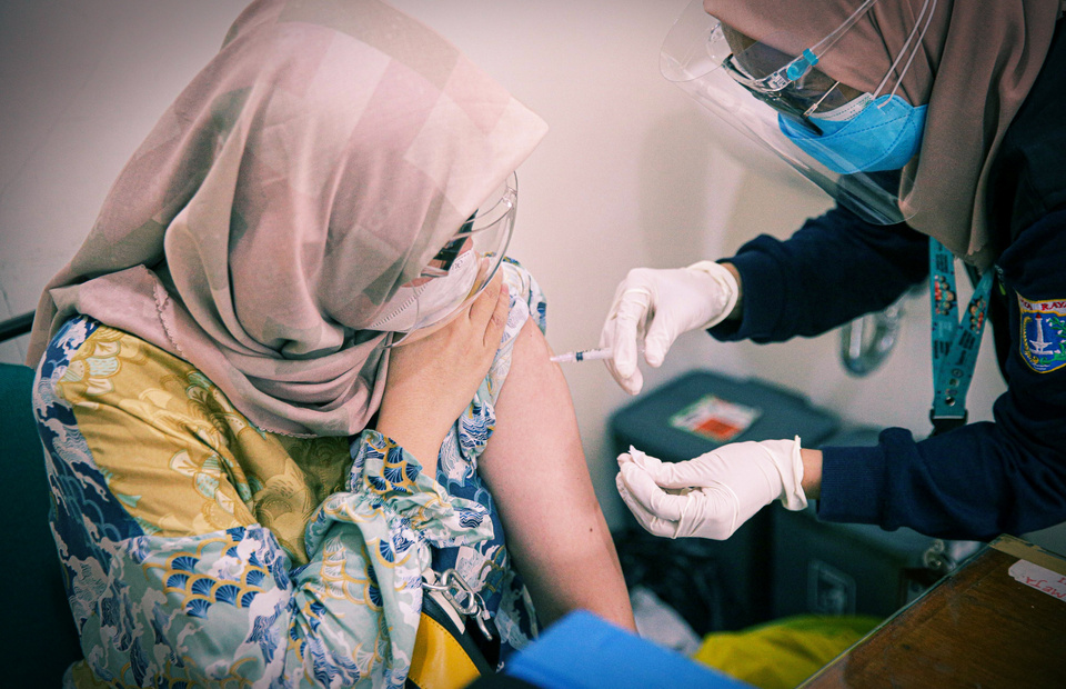 A woman receives a jab of Pfizer vaccine against Covid-19 at Lebak Bulus Public Health Center in East Jakarta on August 23. 2021. (Beritasatu Photo/Joanito De Saojoao)