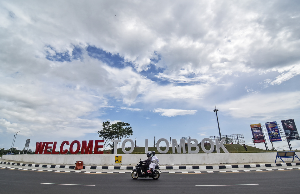 Motorcycle riders pass by welcome to Lombok sign in front of Lombok International Airport in Central Lombok, West Nusa Tenggara on Monday, Feb 7, 2022. (Antara Photo/Ahmad Subaidi)