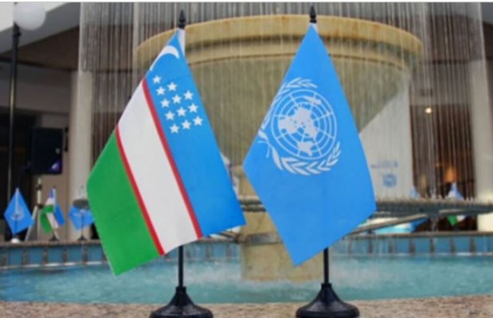 A photo illustration of the flag of Uzbekistan next to that of the United Nations (UN).
