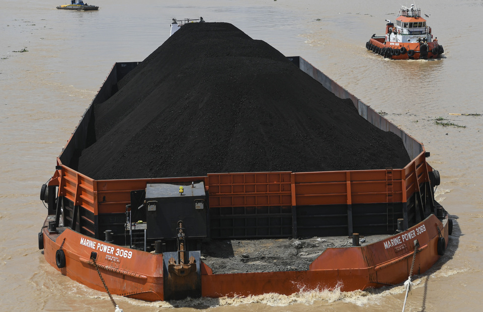 A tugboat carrying coal pile sails along the Musi River in the South Sumatra capital of Palembang on January 15, 2020. (Antara photo)
