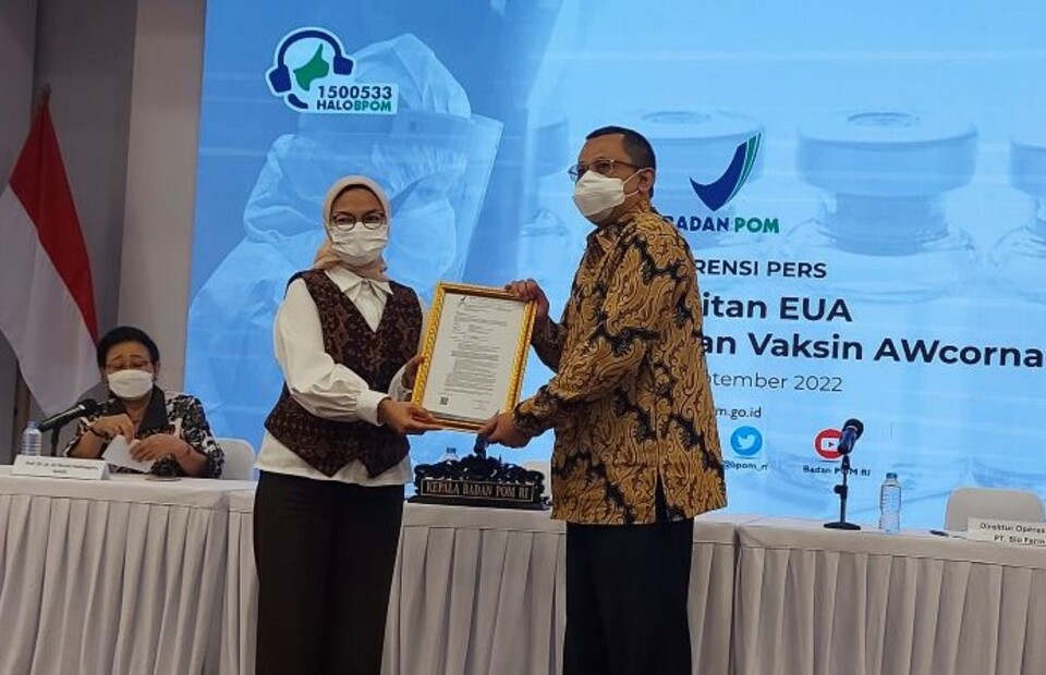BPOM Head Penny Lukito, left, hands cerficate of emergency use authorization for IndoVac vaccine to Bio Farma Operation Director Rahman Roestan in Jakarta on Sept. 30, 2022. (Antara Photo)