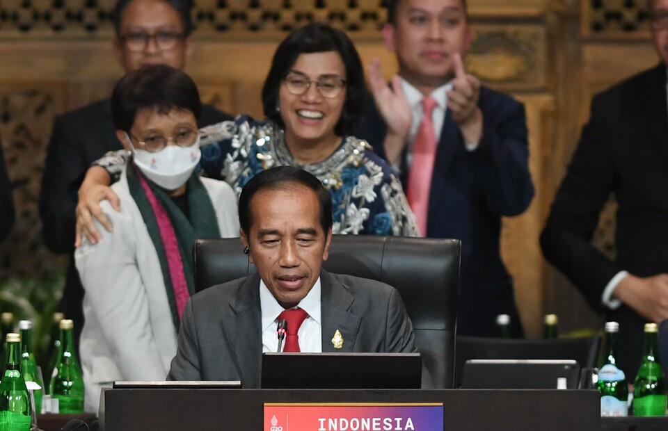 President Joko WIdodo, center, delivers a speech to conclude the G20 Summit as Finance Minister Sri Mulyani hugs Foreign Minister Retno Marsudi on the background in Bali on November 16, 2022. (Antara photo)