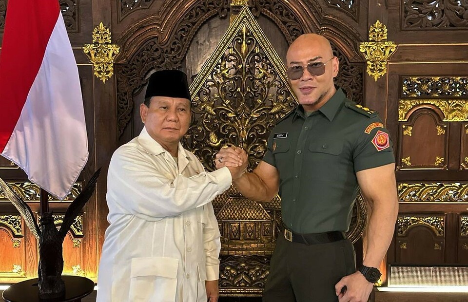YouTube personality Deddy Corbuzier, right, shakes hands with Defense Minister Prabowo Subianto in this photo he posted on Instagram on December 10, 2022.