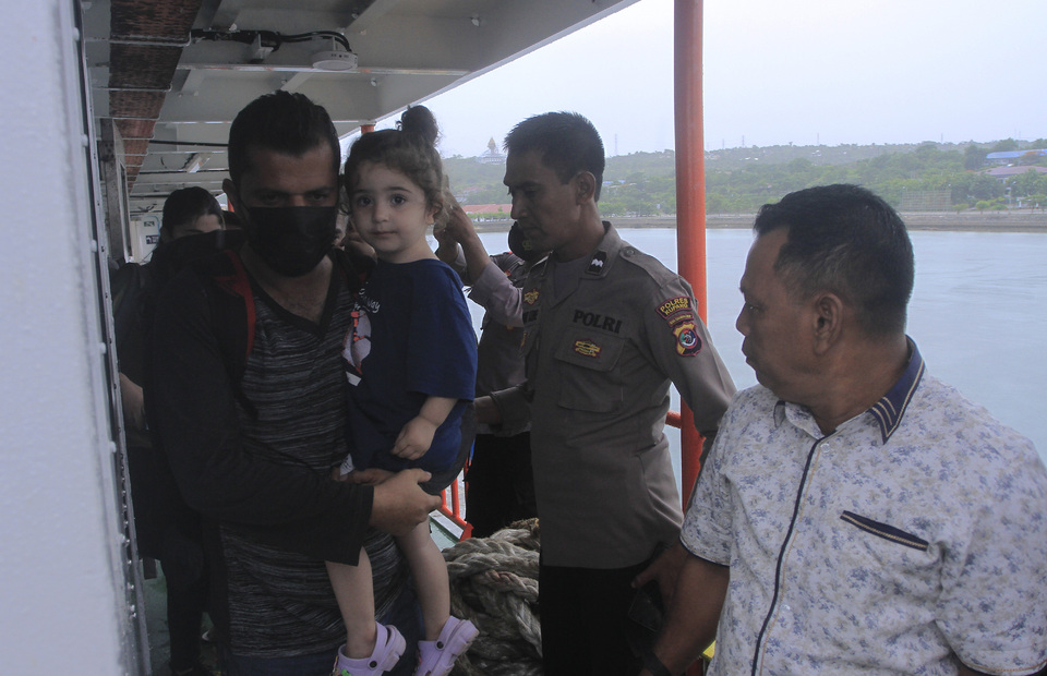 An Iraqi immigrant and his daughter disembark a vessel at Bolok Kupang Port in East Nusa Tenggara on December 17, 2022. Local authorities hold 13 Iraqi nationals at the immigration detention facility in Kupang after they were rejected entry by the Australian coastguard. (Antara photo)