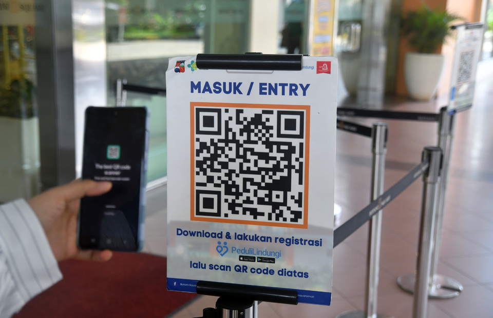 A visitor scans the PeduliLindungi barcode before entering the Botani Square Mall in Bogor on Jan. 4, 2023. (Antara Photo/Arif Firmansyah)