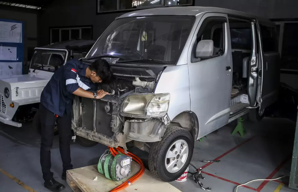 A technician works on converting a convetional car into an electric vehicle (EV) in Lengkong, South Tangerang on Feb. 3, 2023. (Antara Photo/Rivan Awal Lingga)