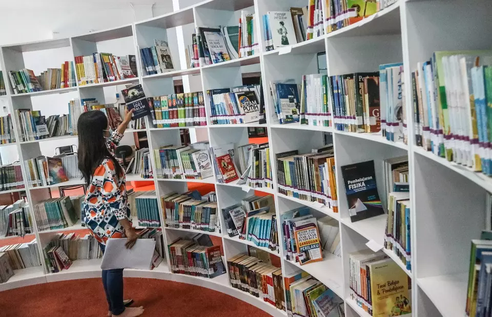 A woman browses the book shelves at the Palangka Raya library and archives department in Central Kalimantan on Jan. 16, 2023. (Antara Photo/Auliya Rahman)