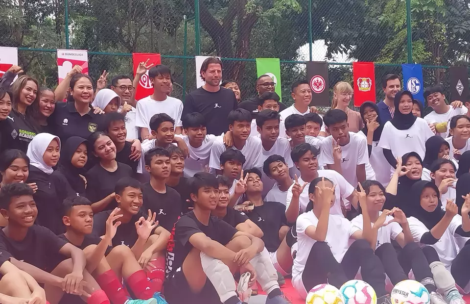 Former Borussia Dortmund’s goalkeeper Roman Weidenfeller takes a picture with young Indonesian footballers at the refurbished football pitch at RPTRA Bhinneka in Jakarta on Feb. 11, 2023. The pitch revamp is part of the Bundesliga's pitch refurbishing project Common Ground. (JG Photo/Jayanty Nada Shofa)