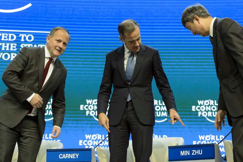 From left: ECB member of the board Benoit Coeure, Bank of England governor Mark Carney, and IMF deputy managing director Min Zhu participate in a panel session at the World Economic Forum. (EPA Photo/Laurent Gillieron)