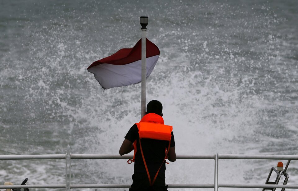 An Indonesia rescue team member stands on the deck of SAR ship KN Purworejo during a search operation for passengers of AirAsia QZ8501 in the Java Sea January 3, 2015. Ships searching for the wreck of an AirAsia passenger jet that crashed with 162 people on board have pinpointed two "big objects" on the sea floor, the head of Indonesia