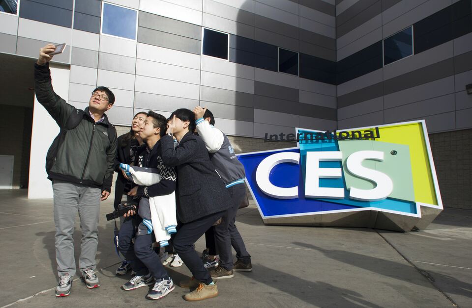 South Korean university students take a selfie in front of an International CES sign at the Las Vegas Convention Center in Las Vegas, Nevada, in the US on Jan. 4, 2015. (Reuters Photo/Steve Marcus)