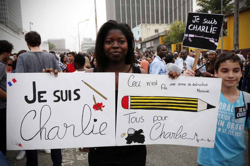A woman holds posters during a solidarity demonstration to pay tribute to the victims of the shootings in France, in front of the French embassy in Abidjan, Ivory Cost, on Jan. 11, 2015. The poster on the left reads: ‘I am Charlie’. (Reuters Photo/Thierry Gouegnon)