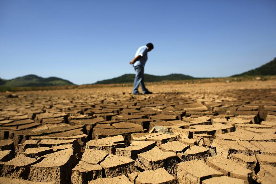 A worker from the Sao Paulo state company that provides water and sewage services to residential, commercial and industrial areas looks at the cracked ground of near Jaguary dam in Braganca Paulista, 100 kilometers from Sao Paulo, in this file photo taken on Jan. 31, 2014. (Reuters Photo/Nacho Doce)