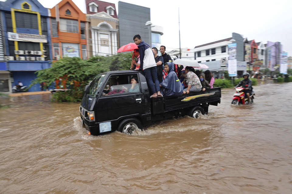 Residents braving the floods in Kelapa Gading on Friday. (Antara Photo/Wahyu Putro A.)