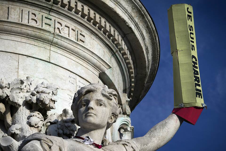 A picture taken on Jan. 18, 2015 shows a giant pencil reading ‘Je suis Charlie’ (‘I am Charlie’) set up on the arm of a relief adoring the plinth of the statue of Marianne at the Place de la Republique, in Paris. (AFP Photo/Joel Saget)