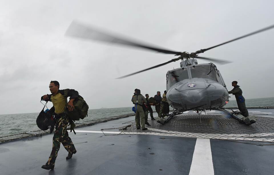 Officers arrive via helicopter on the Indonesian Navy vessel KRI Bung Tomo as it takes part in search operations on January 1, 2015 for victims and debris from AirAsia flight QZ8501 that crashed in the Java Sea. (AFP Photo/Adek Berry)