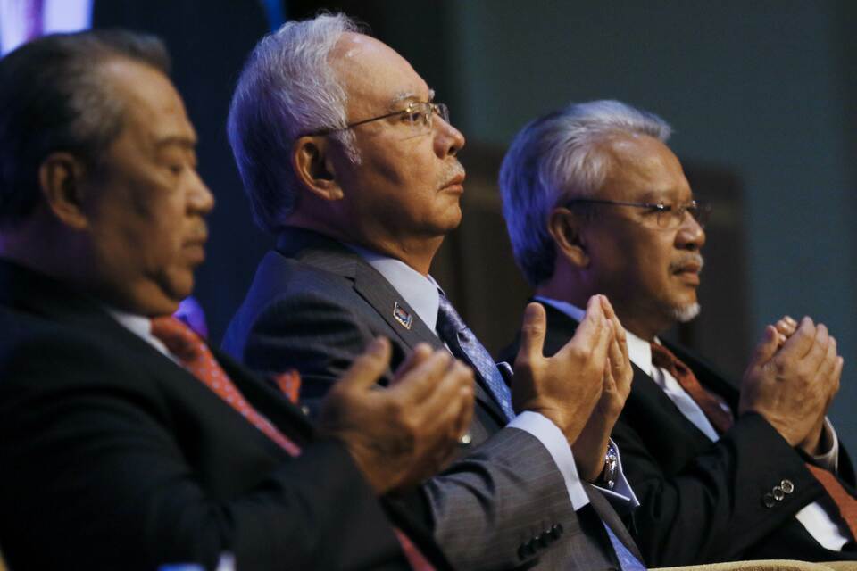 Malaysian Prime Minister Najib Razak (C) and his deputy Muhyiddin Yassin (L) offer prayers before the Budget Revision in Putrajaya on January 20, 2015. Malaysia said on Wednesday it would investigate corruption allegations against government officials in a multi-million dollar property deal in Australia, the latest in a series of scandals plaguing Najib’s government. (AFP Photo/Ahmad Yusni)