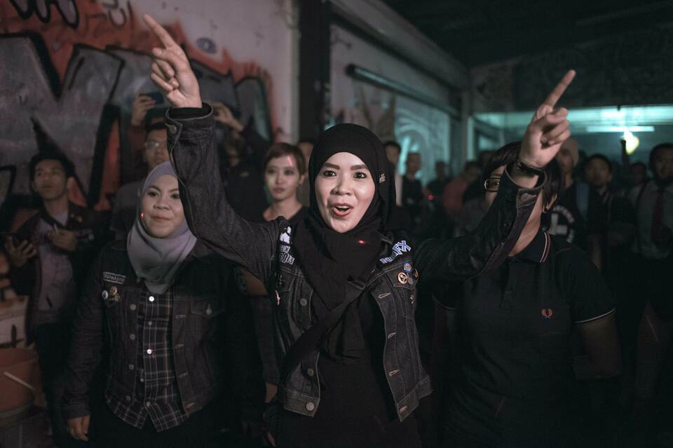 A malaysian woman gestures at live band performance during skinhead meeting in Kuala Lumpur on January 17, 2015. Hundreds of people turn up in Kuala Lumpur to watch skinhead bands group from Japan and Thailand performing live for a two-day event on January 17 and 18 January, 2015. (AFP Photo/Mohd Rasfan)