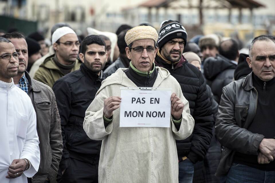A Muslim man holds a placard, reading "Not in my name", during a gathering on Jan. 9, 2015 near the mosque of Saint-Etienne, eastern France. (AFP Photo/Jean Philippe Ksiazek)