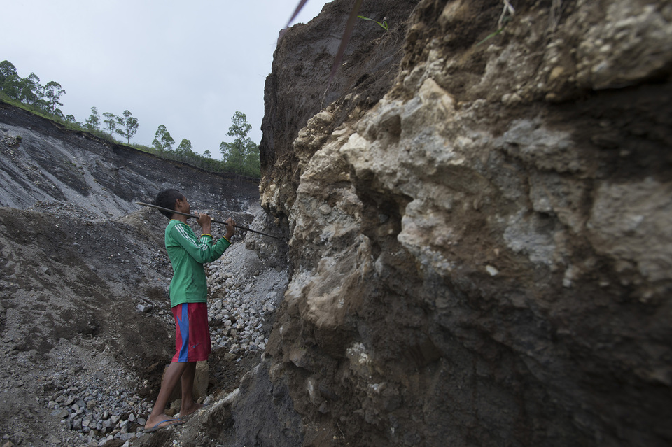 A boy breaks stones on sand mining sites in the village of Naru, Ngada, East Nusa Tenggara, on Jan. 8 , 2015. In Lombok, two Australians were nabbed on allegations of illegal mining activity. (Antara Photo/Rosa Panggabean)