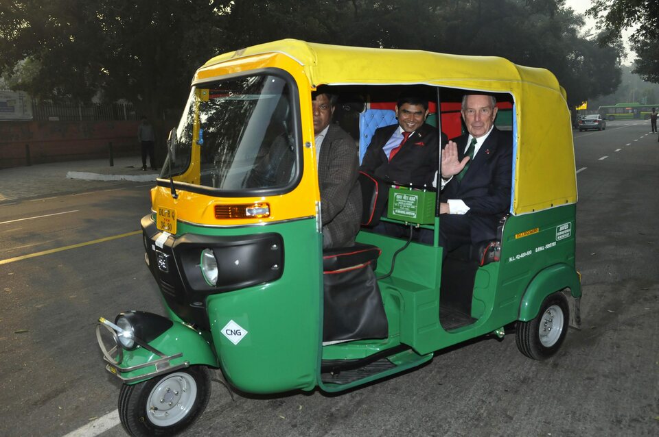 Former New York Mayor and UN Special envoy Michael Bloomberg, right, arrives in an Autorickshaw to attend the Conference on the new investment destination for renewable energy at Hotel Ashok in New Delhi, India, on Feb. 2015. (EPA Photo)