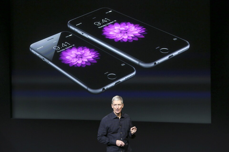 Apple chief executive Tim Cook stands in front of a screen displaying the IPhone 6 during a presentation at Apple headquarters in Cupertino, California in this Oct.16, 2014 file photo. (Reuters Photo/Robert Galbraith)