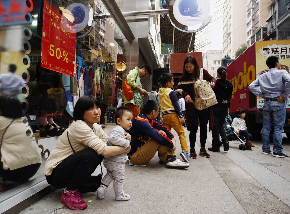 Mainland Chinese visitors rest outside a shop at a shopping district in Hong Kong February 24, 2015. The number of mainland Chinese visitors to Hong Kong during the Lunar New Year holidays fell for the first time in about 20 years as they have felt increasingly unwelcome amid political unrest in the city.  (Reuters Photo/Liau Chung-ren)   
