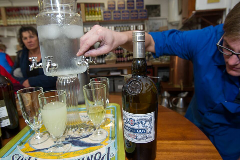 An employee of Armand Guy's distillery serves by the traditional way the absinthe alcohol into the Armand Guy distillery based in Pontarlier on Jan. 13, 2015. (AFP Photo/ Sebastien Bozon)