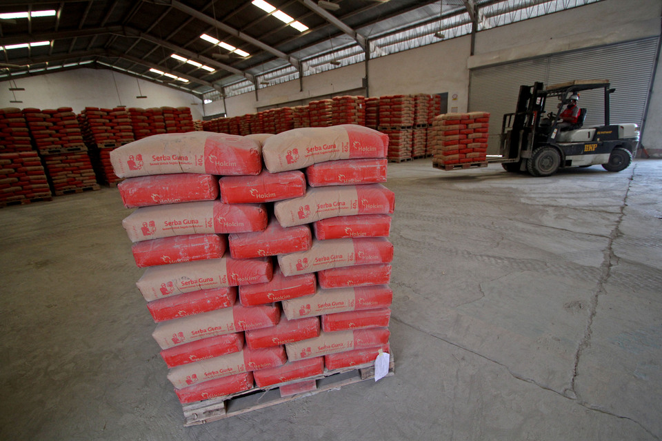 Workers arrange cement sacks at a Holcim warehouse in this file photo. (Antara Photo/Noveradika)