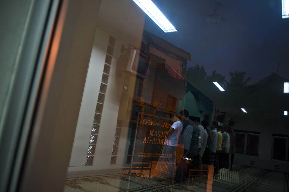 In this photograph taken on Jan. 21, 2015, devotees of the minority Ahmadi Muslim community are reflected in a window while praying at the al-Hidayah mosque in Jakarta. (AFP Photo/Romeo Gacad)