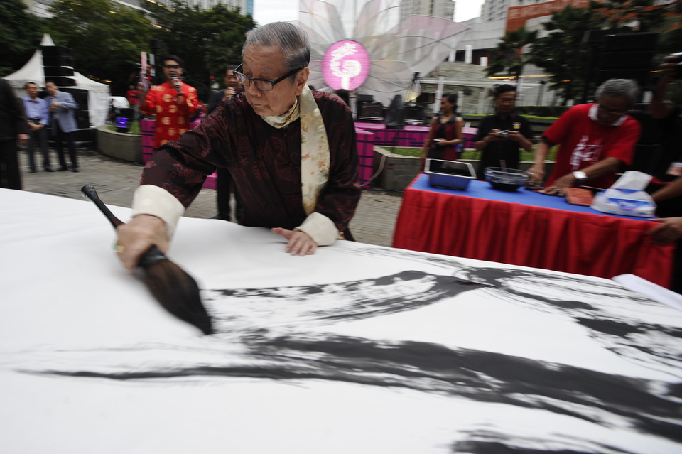 Chinese calligraphy artist Abidin Tane uses a brush for a work in one of the shopping malls in Jakarta, on Feb. 19, 2015. Shopkeepers attended celebrations at nearby temples to herald the Year of the Wood Goat with traditions including the lion dance. (Antara Photo/Wahyu Putro A.)