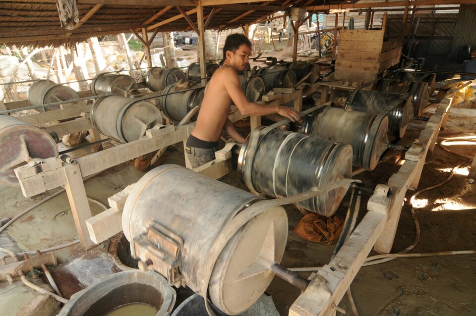 A man uses ball mills to grind gold ore to form an amalgam with mercury. (Antara Photo/Basri Marzuki)