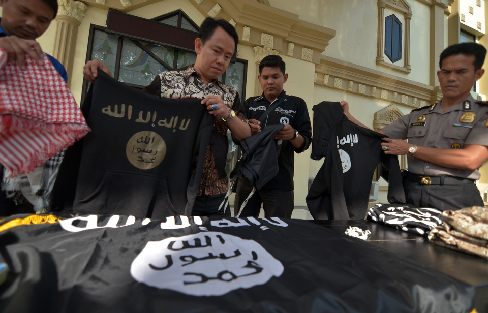 Police officers present items seized from a young Islamic State supporter, last week in Jambi. (Antara Photo/Wahdi Septiawan) 