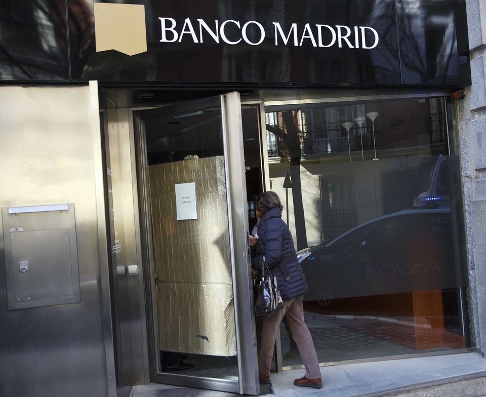 A woman enters a Banco Madrid branch with a closed sign on its door in Madrid, March 16, 2015. Banco Madrid, a subsidiary of Andorran lender Banca Privada d'Andorra (BPA), has requested entry into insolvency proceedings and will suspend activity after significant deposit withdrawals, the Bank of Spain said on Monday. Andorra seized control of privately owned BPA last week as it investigates U.S. allegations of money laundering, and replaced executives with provisional administrators.  REUTERS/Andrea Comas  (SPAIN - Tags: BUSINESS CRIME LAW POLITICS)