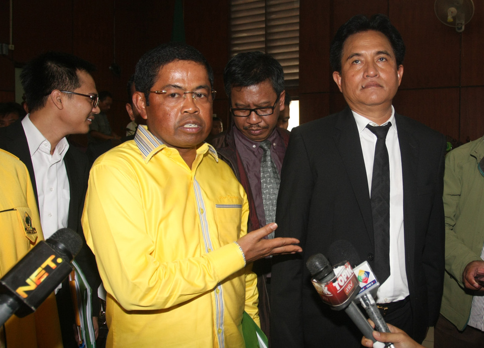 Golkar Party secretary general Idrus Marham, left, and attorney Yusril Ihza Mahendra, right, answer journalists’ questions outside the North Jakarta District Court on Tuesday. (Antara Photo/Reno Esnir)