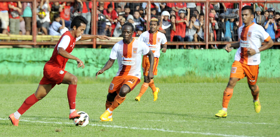Pusamania Borneo FC, in orange and white, in action against PSM Makassar. (Antara Photo/Yusran Uccang)