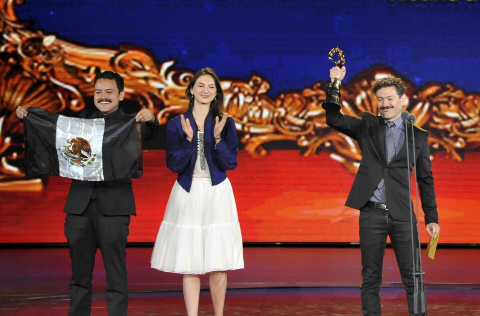 Mexican director Bernardo Arellano (R) raises a Tiantan Award trophy as he celebrates with cast members on the stage after winning the best film award, at the closing ceremony of the 5th Beijing International Film Festival in Beijing, April 23, 2015. (Reuters Photo/Stringer)
