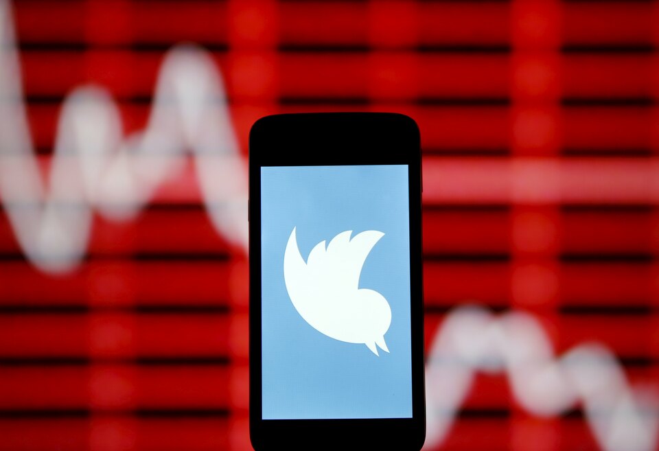 The Twitter logo is shown on smartphone in front of a displayed stock graph in central Bosnian town of Zenica, Bosnia and Herzegovina, in this April 29, 2015 photo illustration. (Reuters/Dado Ruvic)