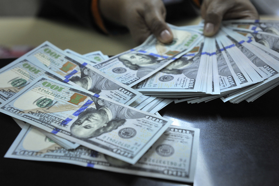 A teller at BNI counts US dollar notes in Jakarta on April 15, 2015.  (Antara Photo/Puspa Perwitasari)