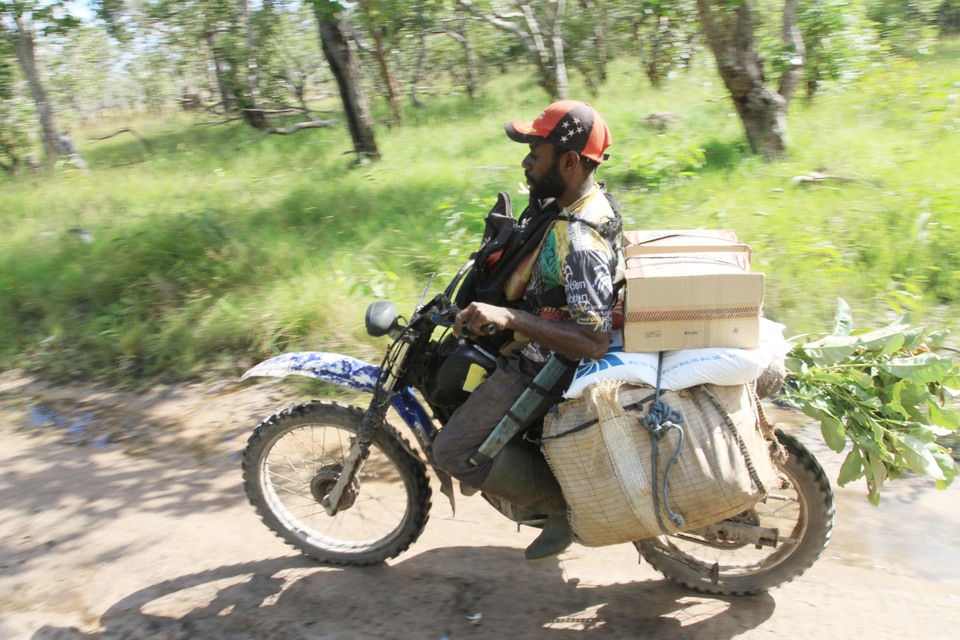 A motorcycle taxi driver from Merauke takes goods over the border to Papua New Guinea.  (Antara Photo/Akbar Nugroho Gumay)