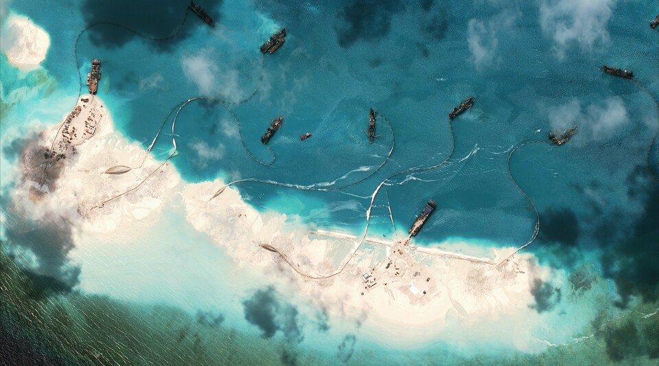 This handout photo taken on March 17, 2015 by satellite imagery provider DigitalGlobe and released to AFP by the Asia Maritime Transparency Initiative department at the Center for Strategic and International Studies (CSSI) think tank shows a satellite image of vessels purportedly dredging sand at Mischief Reef in the Spratly Islands in the disputed South China Sea.  (AFP Photo/CSIS Asia Maritime Transparency Initiative/Digitalglobe)