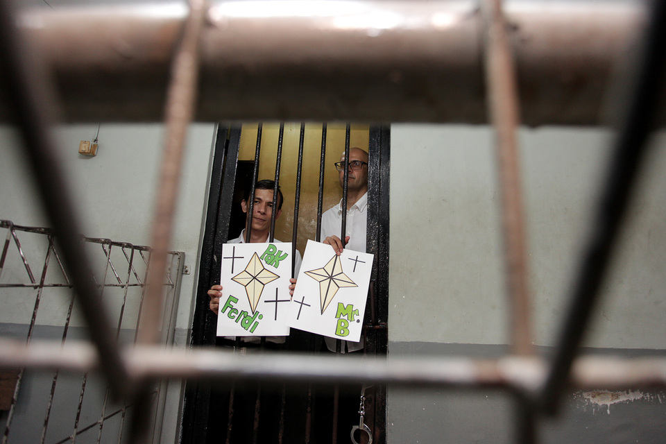JIS staffers Ferdinand Tjiong, left, and Neil Bantleman, seen at the South Jakarta District Court last month, showing pictures made by their students.  (Antara Photo/Muhammad Adimaja)