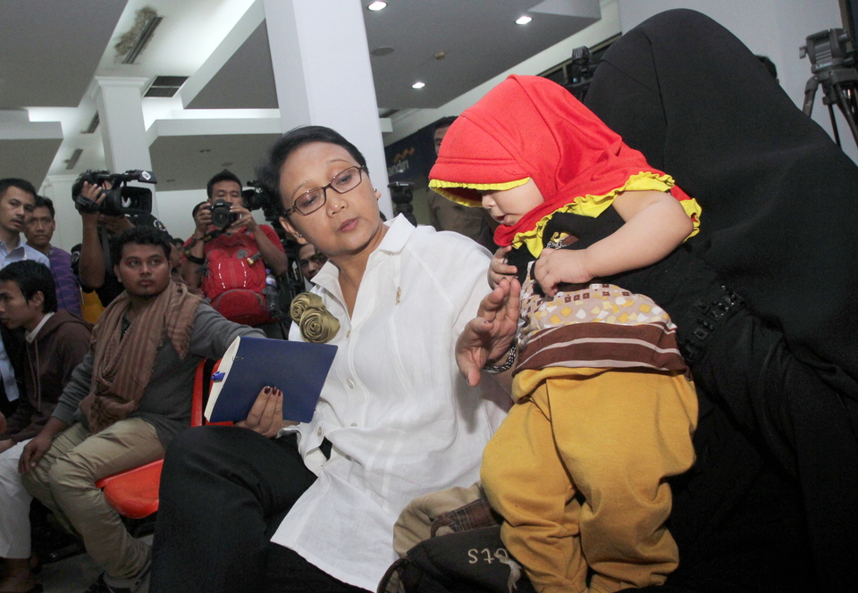 An Indonesian woman and her child are greeted by Foreign Minister Retno Marsudi, center, upon arrival in Jakarta on Sunday, part of a batch of more than 100 Indonesians evacuated from Yemen as the country descends into sectarian violence. (Antara Photo/Muhammad Iqbal)