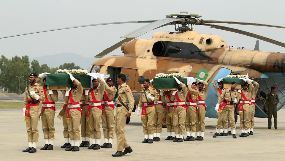 Pakistani army soldiers carry coffins, wrapped in national flags and carrying bodies of helicopter crash victims, at the Nur Khan air base in Islamabad on May 9. (Reuters Photo/Faisal Mahmood)