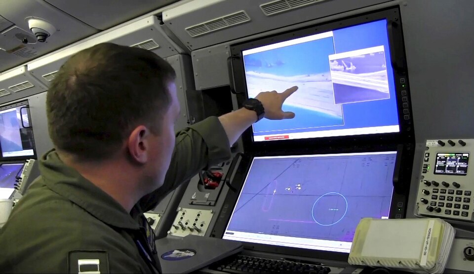 A US Navy crewman aboard a P-8A Poseidon surveillance aircraft views a computer screen purportedly showing Chinese construction on the reclaimed land of Fiery Cross Reef in the disputed Spratly Islands in the South China Sea, in this file still image from video provided by the United States Navy on May 21, 2015. (Reuters Photo/US Navy)