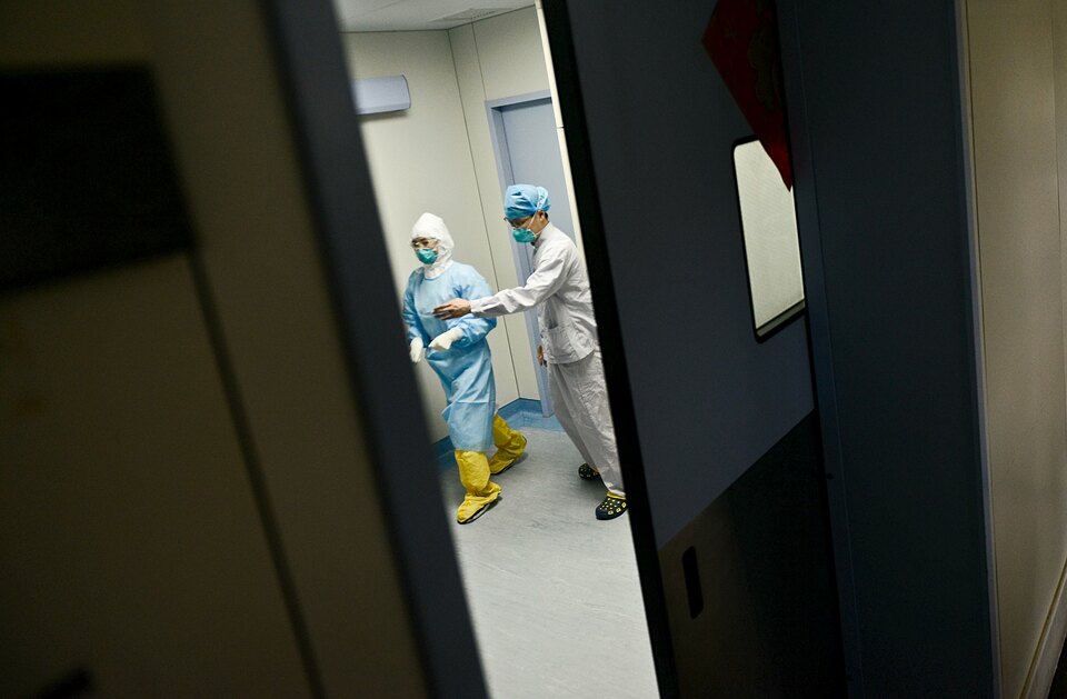 Medical personnel walk past inside the door of an ICU room at a hospital where a South Korean MERS patient is being quarantined and treated, in Huizhou, Guangdong province, China, June 1, 2015. (Reuters Photo/China Daily)